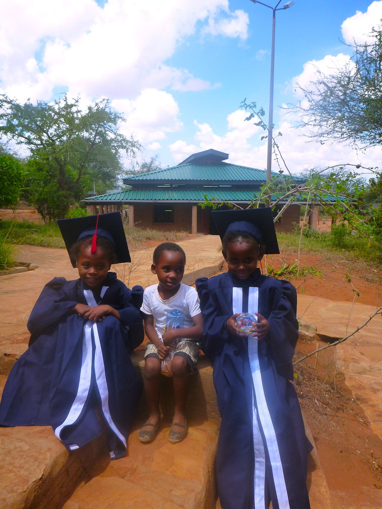 Students pose in their navy cap and gowns tailored at Wildlife Works' very own clothing factory