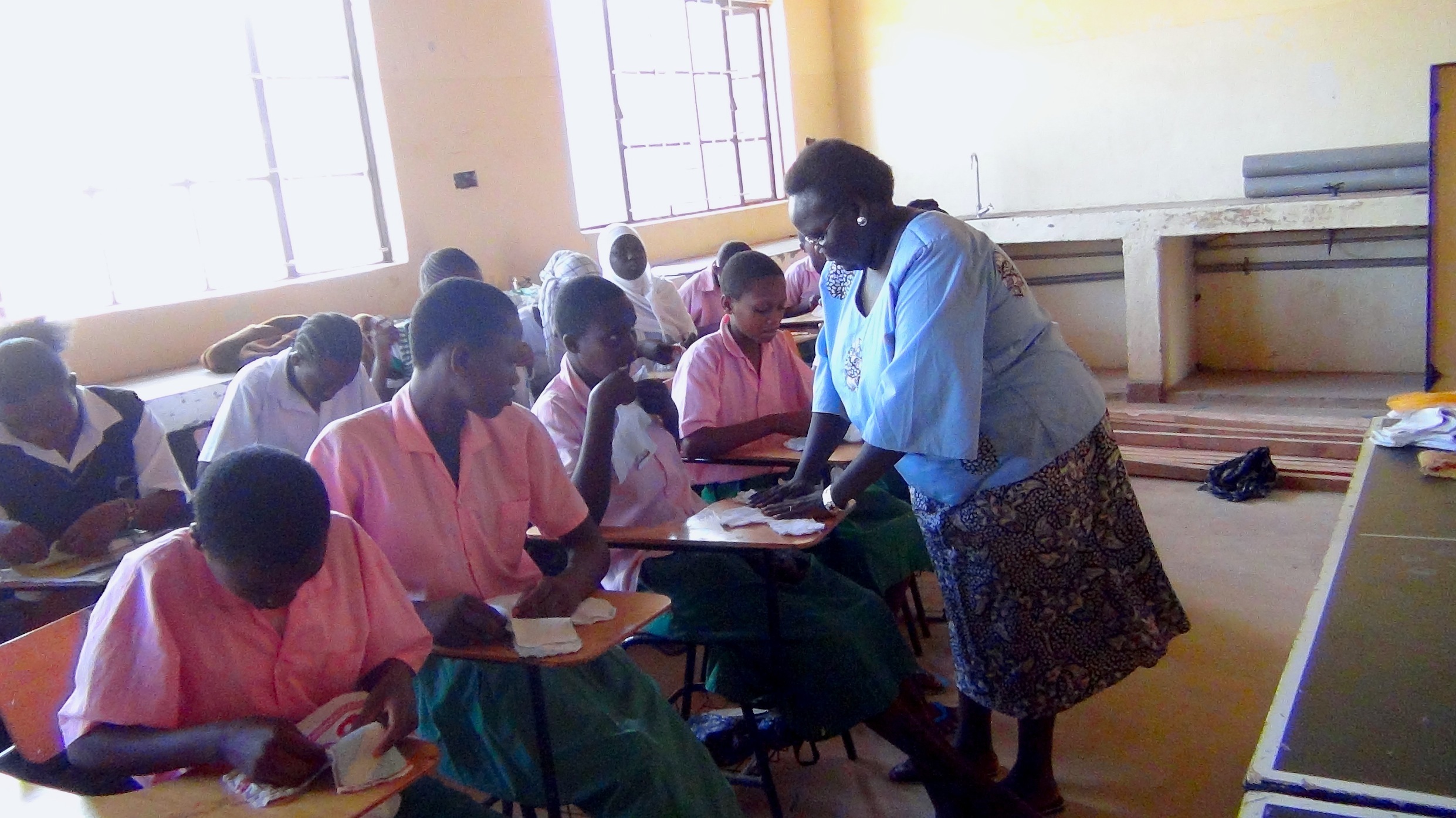 Monica Makori shows one of the students how to arrange materials for the eco-friendly sanitary pads