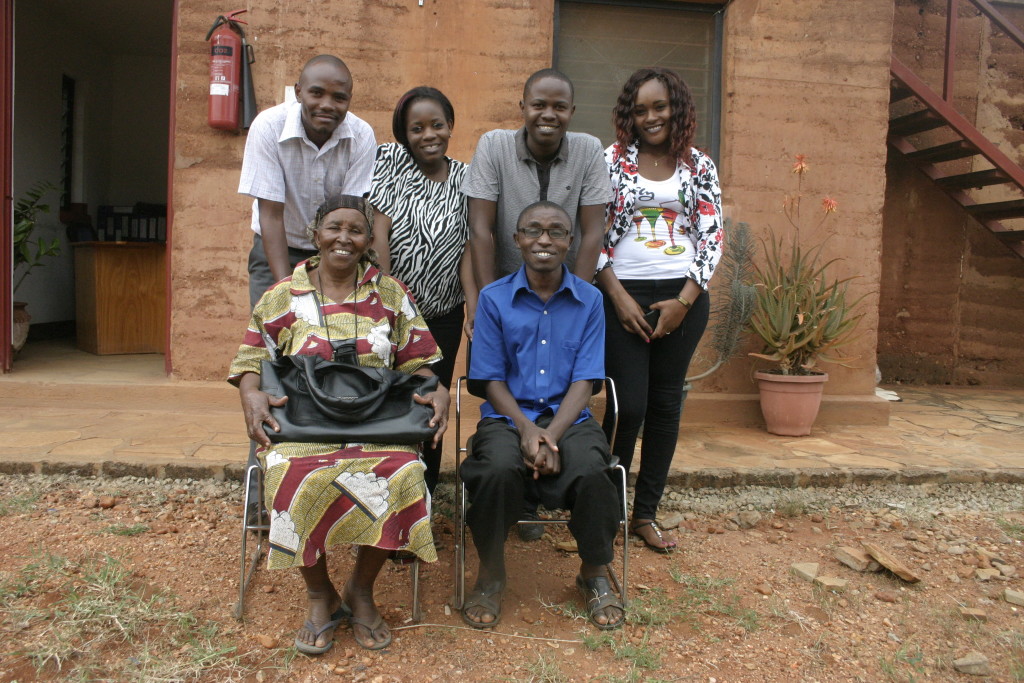 Martin and her Mother sitting on the chair with the rest of community dept posing for a photo before going back to school.