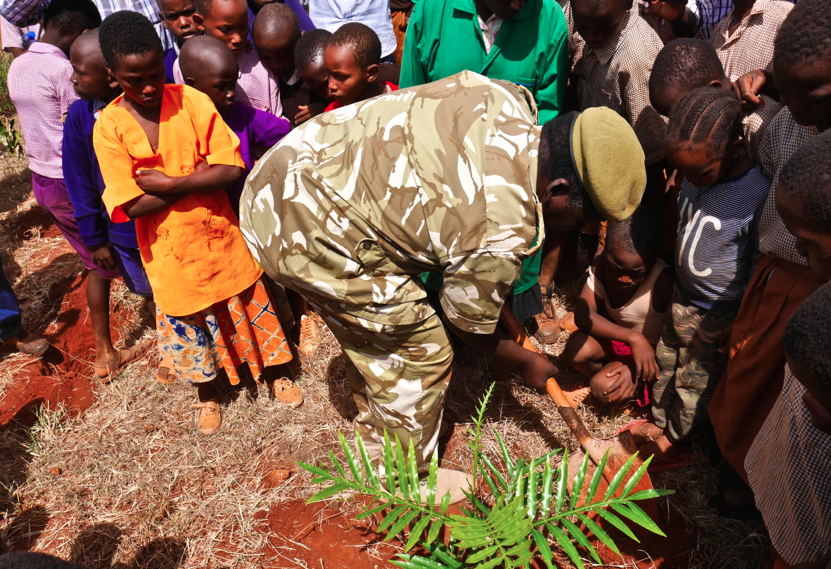 Assistant Director of Kenya Wildlife Service planting a tree seedling